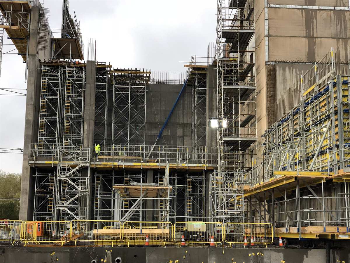 Live construction site with scaffolding, concrete structure and site safety provisions